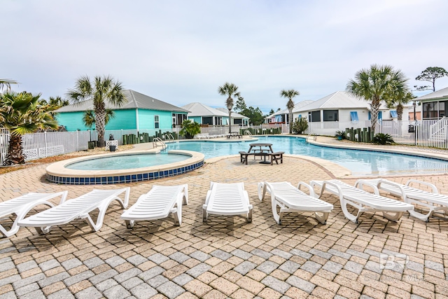 view of pool with a hot tub and a patio area