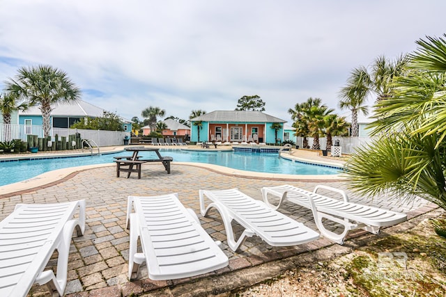 view of swimming pool featuring a patio and an outbuilding