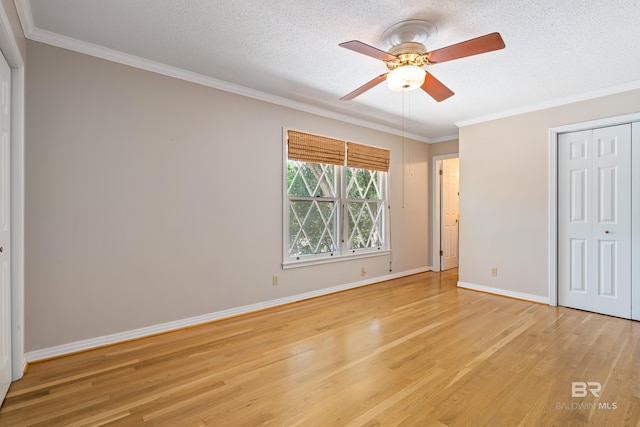 606 Fairhope Ave, Fairhope, AL 36532 - unfurnished bedroom featuring light wood finished floors, ornamental molding, baseboards, a closet, and a textured ceiling