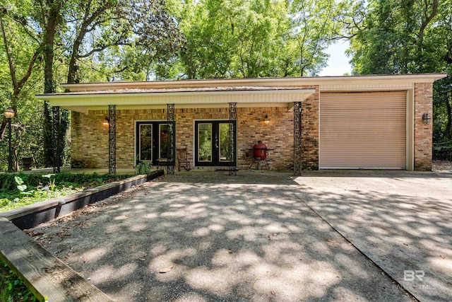 606 Fairhope Ave, Fairhope, AL 36532 - view of front facade with french doors, brick siding, an attached garage, and driveway