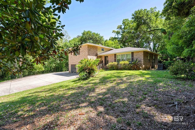 606 Fairhope Ave, Fairhope, AL 36532 - tri-level home featuring brick siding, driveway, cooling unit, a front lawn, and a garage