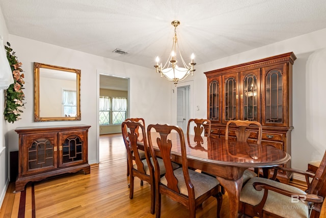 606 Fairhope Ave, Fairhope, AL 36532 - dining area featuring a chandelier, light wood-style flooring, and baseboards