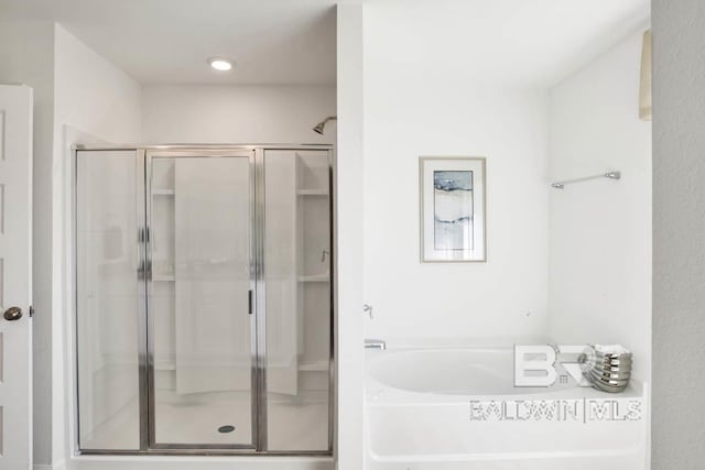 bathroom featuring shower with separate bathtub