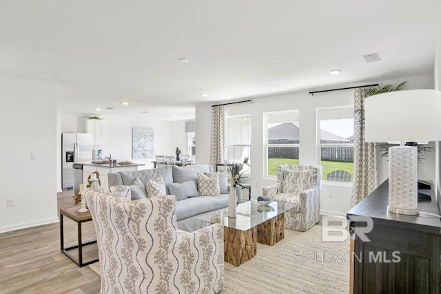 living room with sink and light hardwood / wood-style flooring