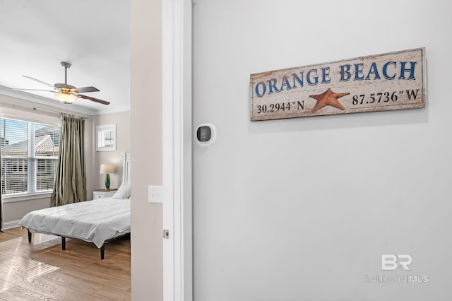 bedroom with ceiling fan, wood-type flooring, and ornamental molding