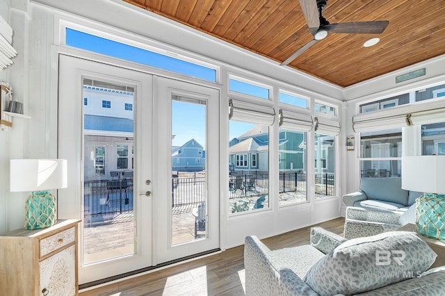 sunroom featuring ceiling fan, wooden ceiling, and french doors