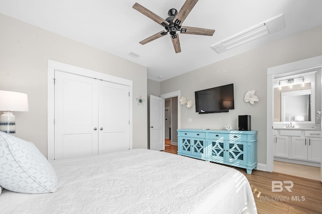 bedroom featuring ceiling fan, light hardwood / wood-style floors, connected bathroom, and a closet