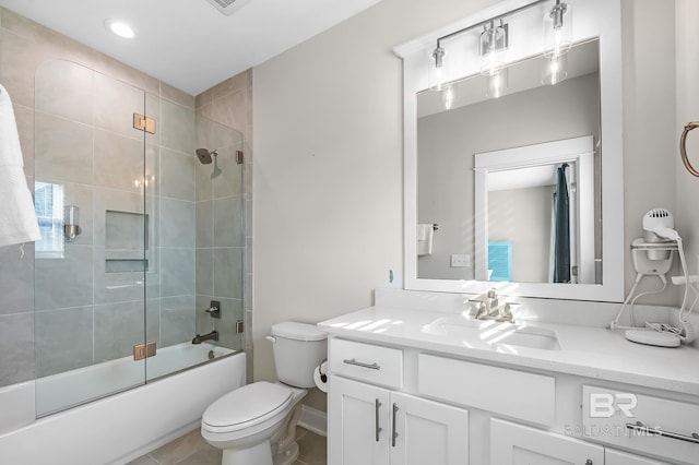 full bathroom featuring tile patterned floors, vanity, toilet, and shower / bath combination with glass door