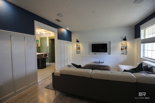 living room featuring a textured ceiling and light wood-type flooring