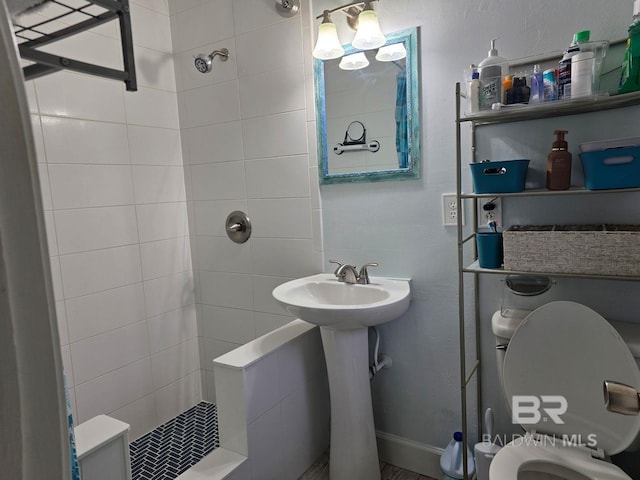 bathroom with tiled shower and toilet