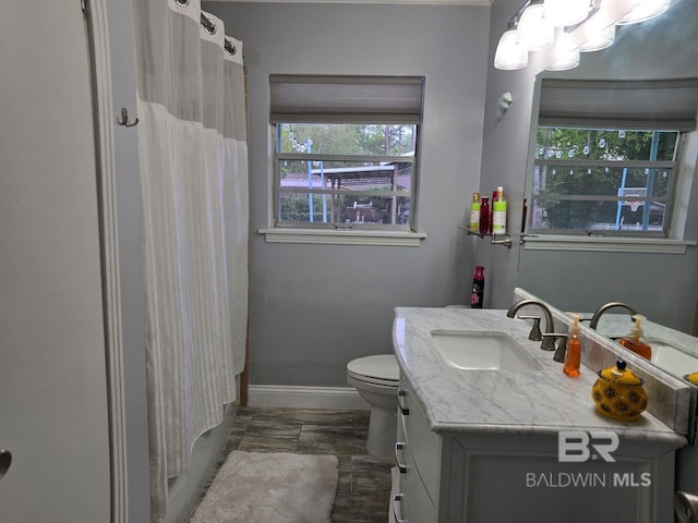 bathroom with hardwood / wood-style flooring, toilet, vanity, and a shower with curtain