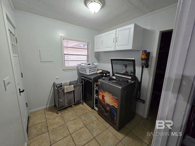 washroom with washer hookup, ornamental molding, light tile patterned floors, a textured ceiling, and cabinets