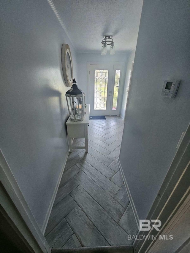 hall with parquet flooring and a textured ceiling