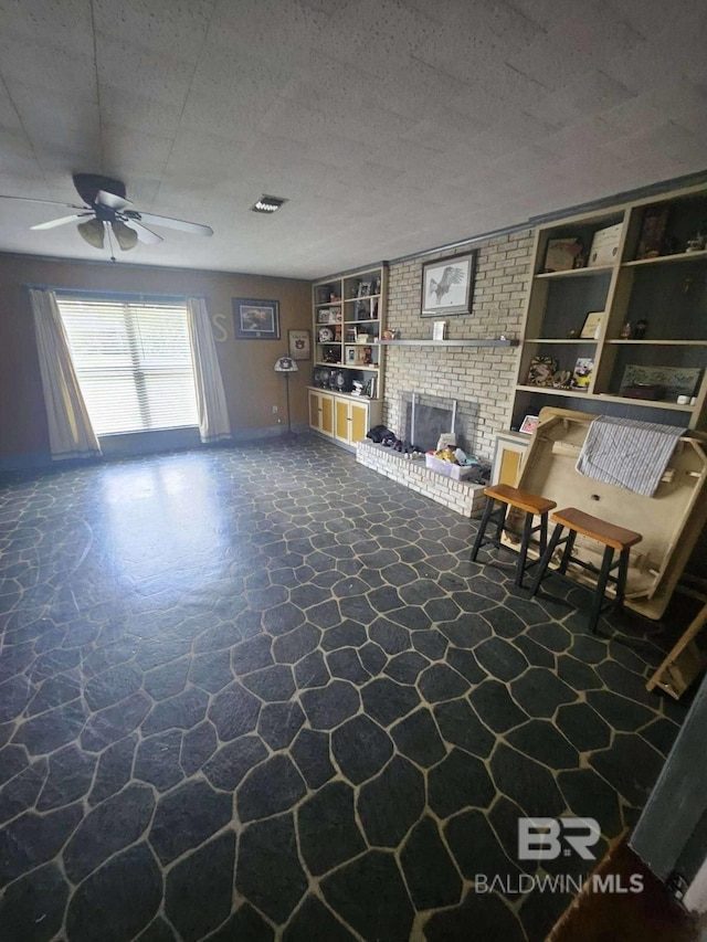 unfurnished living room featuring a fireplace, built in shelves, a textured ceiling, and ceiling fan