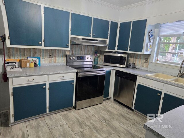 1411 Mcmillan Ave, Brewton, AL 36426 - kitchen with stainless steel appliances, under cabinet range hood, blue cabinetry, crown molding, and light countertops