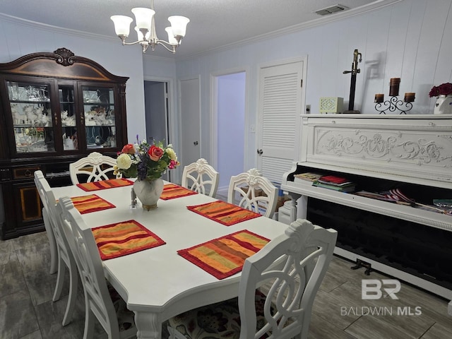 dining space featuring ornamental molding, a textured ceiling, dark hardwood / wood-style floors, and a chandelier