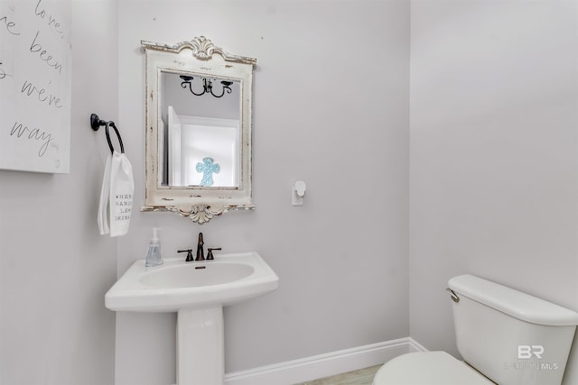 half bath with toilet and baseboards