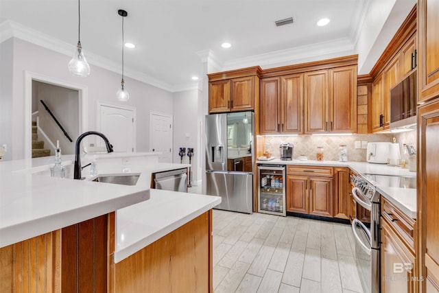 kitchen with visible vents, decorative backsplash, wine cooler, stainless steel appliances, and a sink