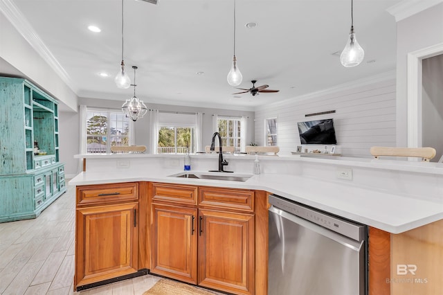 kitchen featuring crown molding, light countertops, stainless steel dishwasher, open floor plan, and a sink