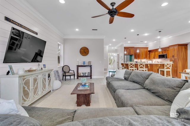 living area featuring ornamental molding and recessed lighting