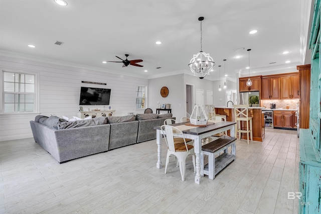 dining room with ornamental molding, recessed lighting, and light wood finished floors