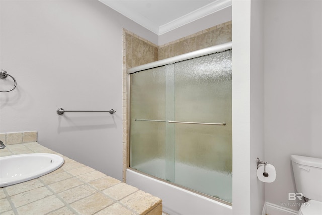 bathroom with ornamental molding, shower / bath combination with glass door, a sink, and toilet