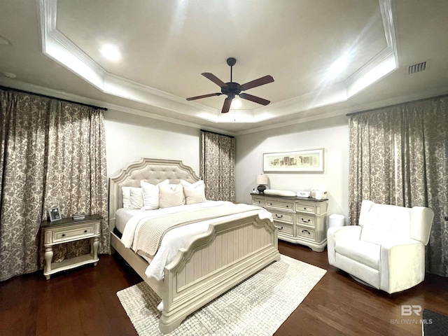 bedroom featuring visible vents, a raised ceiling, and wood finished floors