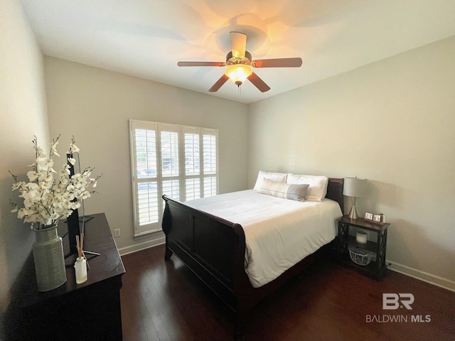 bedroom with dark wood-type flooring, a ceiling fan, and baseboards