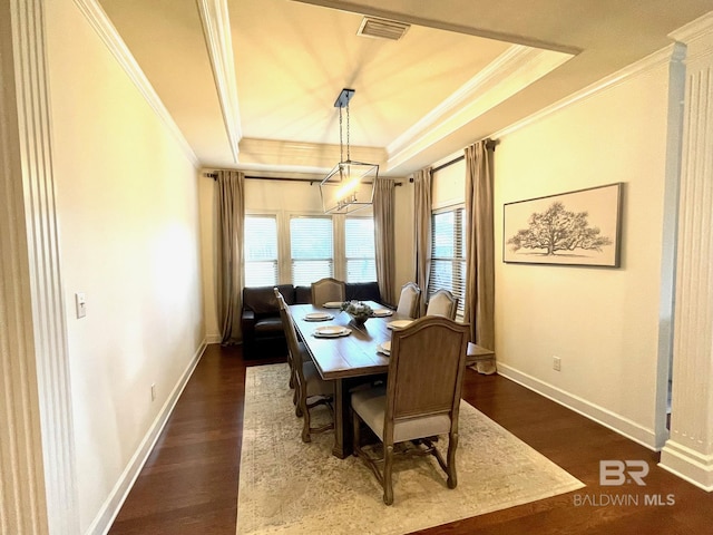 dining room featuring dark wood-style floors, baseboards, crown molding, and a tray ceiling