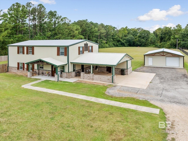 view of front of house with a garage, an outbuilding, and a front yard