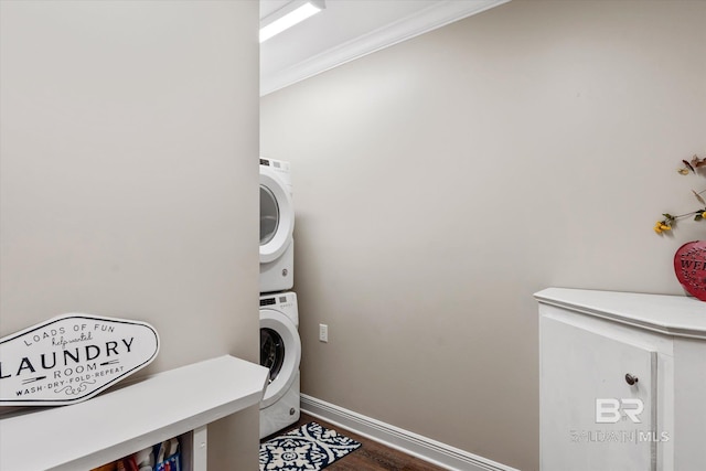 laundry area featuring stacked washer and dryer, crown molding, and dark hardwood / wood-style floors