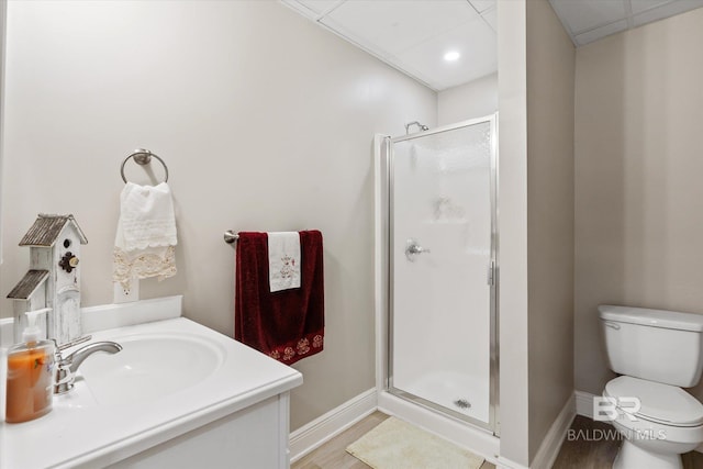 bathroom with vanity, hardwood / wood-style floors, a shower with door, and toilet