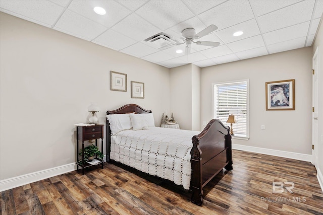 bedroom featuring ceiling fan, a paneled ceiling, and dark hardwood / wood-style flooring