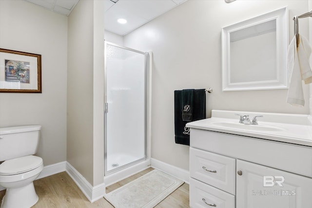 bathroom with hardwood / wood-style flooring, vanity, toilet, and a shower with shower door