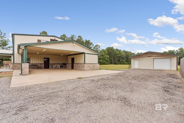 view of side of home featuring a garage and an outbuilding