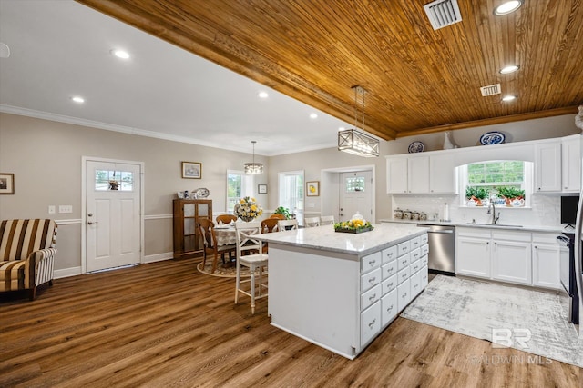 kitchen featuring white cabinetry, a center island, hanging light fixtures, ornamental molding, and dishwasher