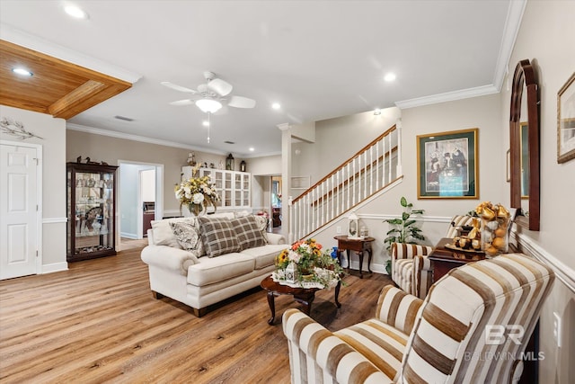 living room with ceiling fan, ornamental molding, and light wood-type flooring