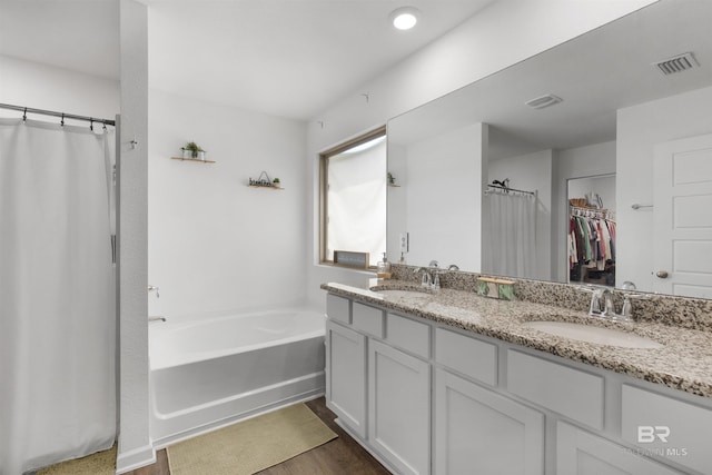 32299 Terranova Loop, Lillian, AL 36549 - bathroom with double vanity, a bath, curtained shower, wood finished floors, and a walk in closet