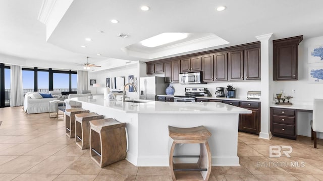23450 Perdido Beach Blvd Unit 2011, Orange Beach, AL 36561 - kitchen with stainless steel appliances, a raised ceiling, light tile patterned flooring, a breakfast bar area, and ornamental molding