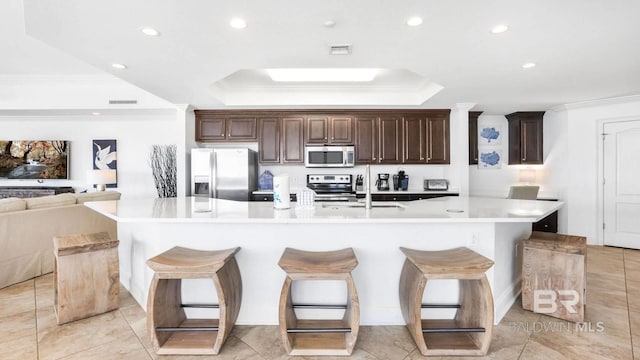 23450 Perdido Beach Blvd Unit 2011, Orange Beach, AL 36561 - kitchen with appliances with stainless steel finishes, light countertops, a kitchen breakfast bar, crown molding, and a spacious island