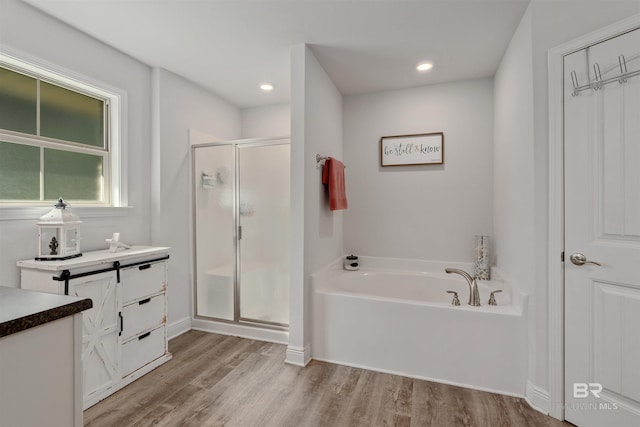 bathroom with vanity, wood-type flooring, and shower with separate bathtub