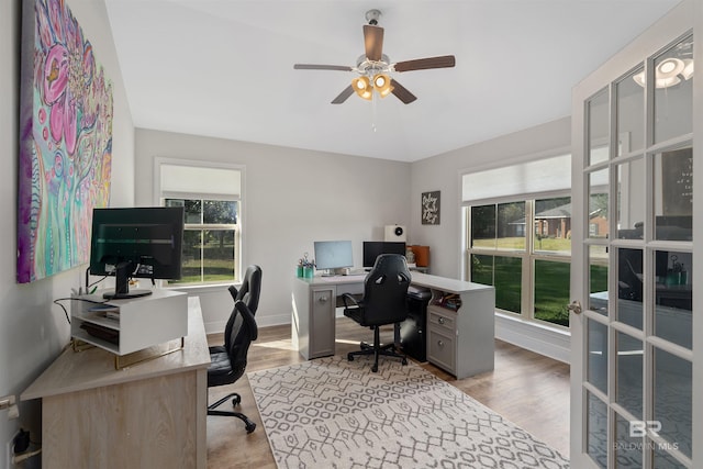 office with light hardwood / wood-style floors and ceiling fan