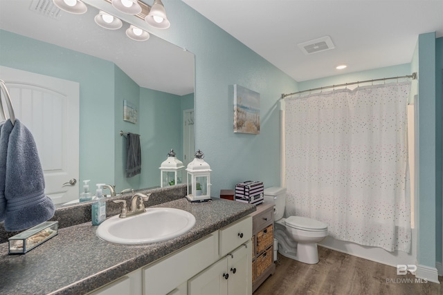 full bathroom with toilet, shower / bath combo, vanity, and wood-type flooring