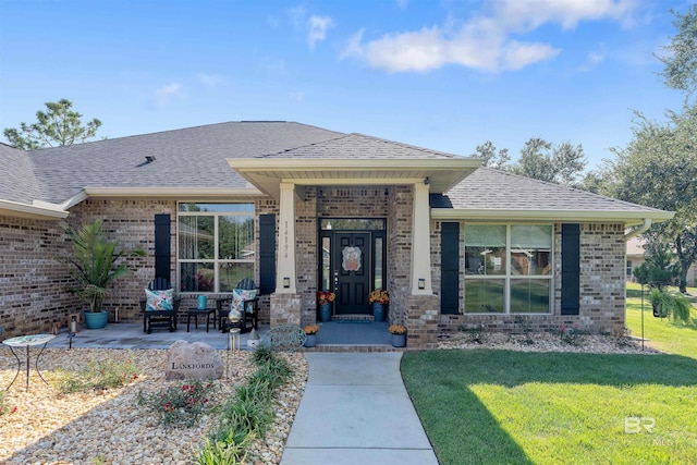 view of exterior entry with a lawn