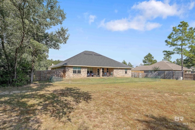 back of house with a patio area and a lawn