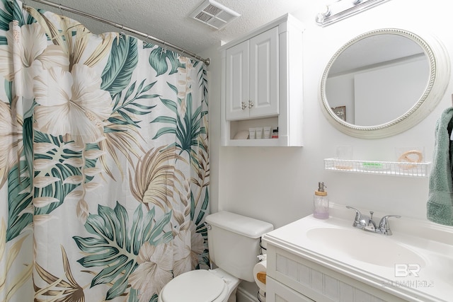 bathroom featuring toilet, a textured ceiling, curtained shower, and vanity