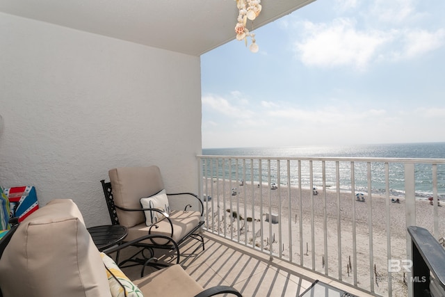 balcony featuring a water view and a beach view