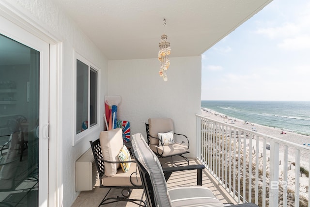 balcony featuring a water view and a beach view