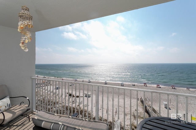 balcony with a water view and a view of the beach