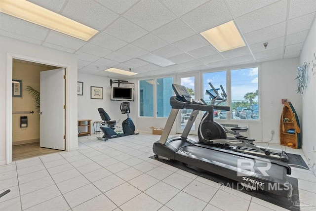 workout area with light tile patterned flooring and a paneled ceiling